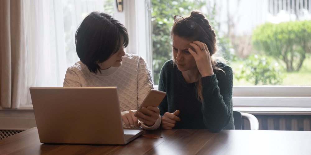 como-evitar-ser-estafado-por-falsas-casas-de-cambio-en-las-redes-sociales-dos-mujeres-sentadas-frente-a-la-computadopra-preocupadas-vcvzlacambios.com