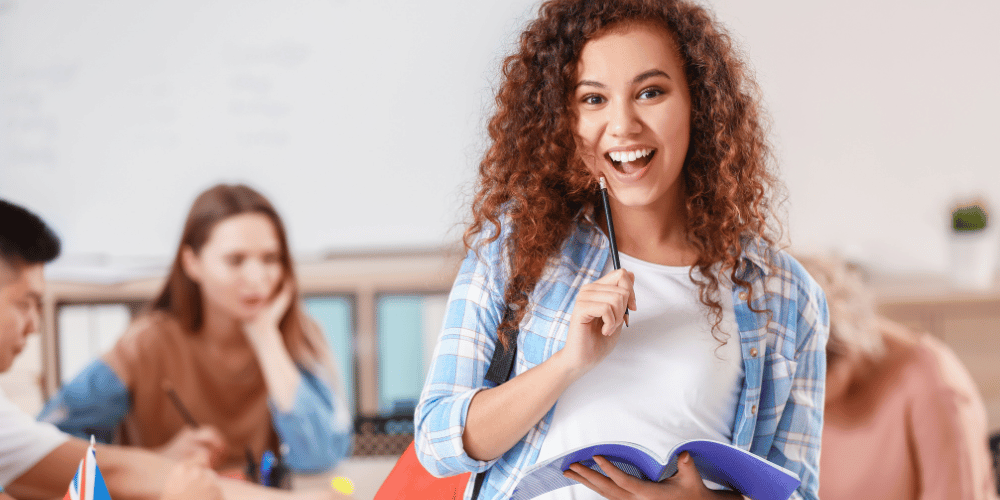 5-consejos-que-necesitas-saber-antes-de-estudiar-en-estados-unidos-joven-estudiante-sonriente-con-cuaderno-y-lapiz-en-la-mano-vcvzlacambios.com